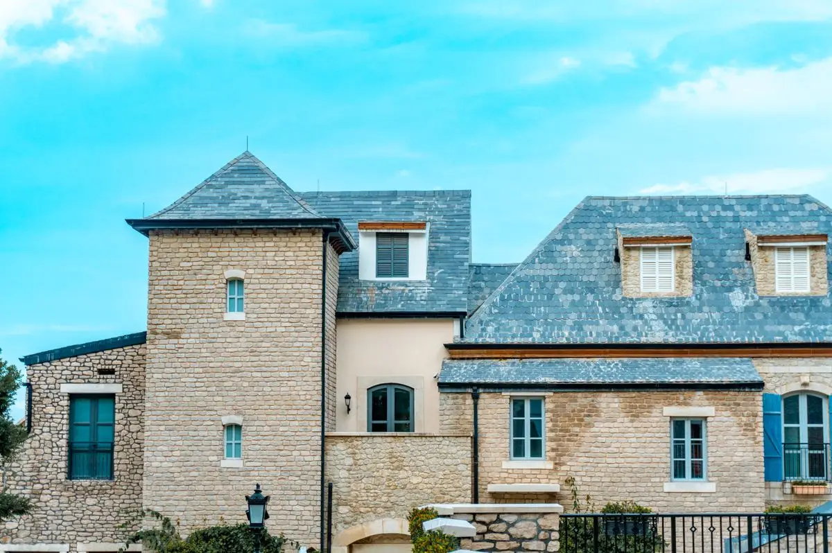 Maison en pierre couverte d’ardoise, avec lucarnes